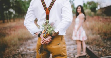 Man with bouquet in hands behind his back in front of woman