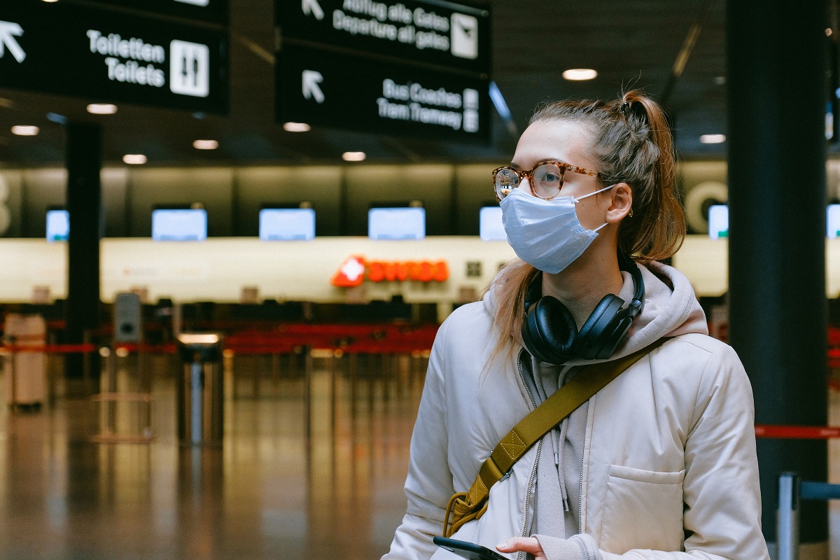 A female traveler wears a mask in an airport.