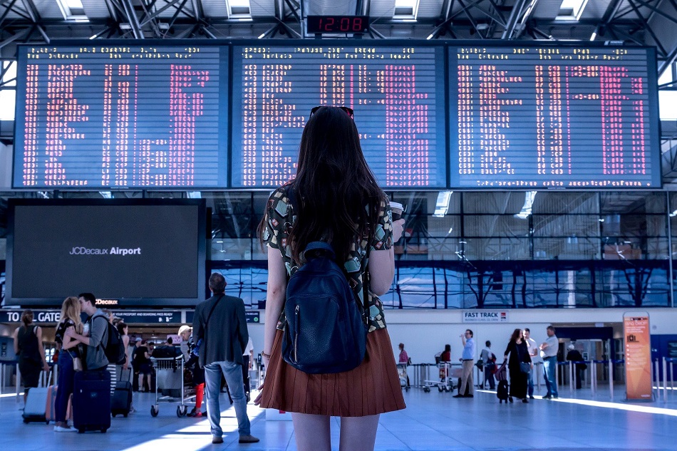 woman at the airport looking through a list of flights